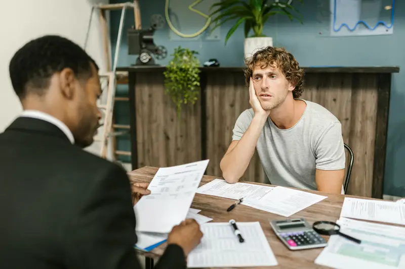 A homeowner looking troubled as he seeks the help of a construction lawyer to help remove a builder's lien that was placed on his house by a contractor