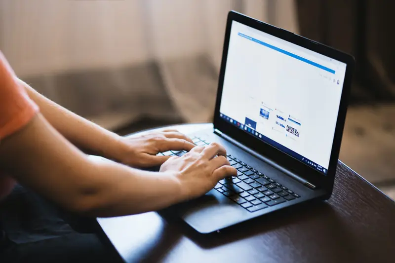 Homeowner performing a request for a lien search online with a title search agent on his laptop