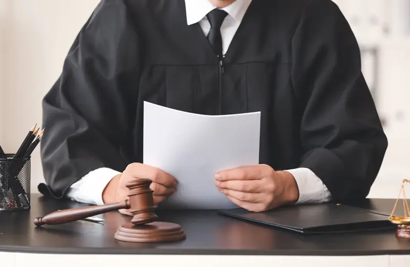 A judge reading the results of a construction dispute to a construction litigator during a court case