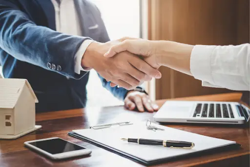 Estate litigation lawyer shaking the hand of a client after going over a will.