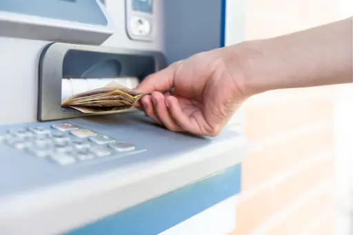 Person withdrawing money from an ATM