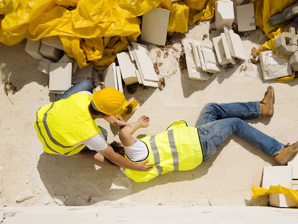 hurt contractor lying on the ground after a fall on a construction site due to safety negligence