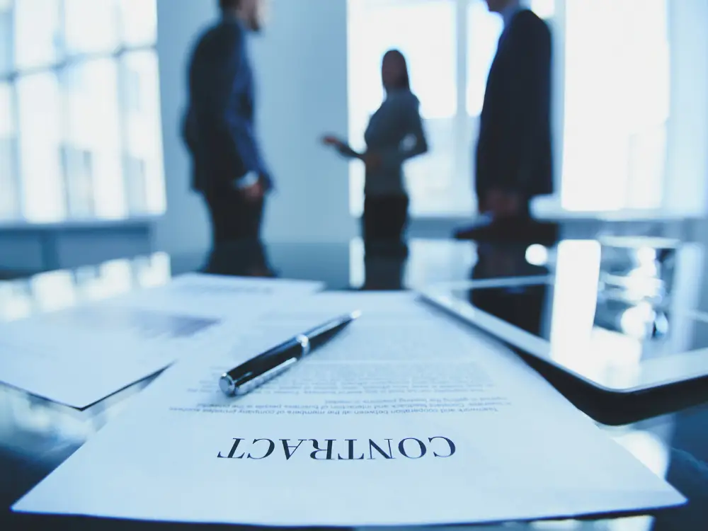 a construction contract on a desk as construction lawyers discuss with their client